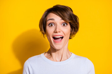 Photo portrait of amazed excited girl with open mouth isolated on bright yellow colored background