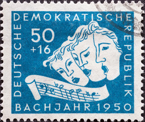 GERMANY, DDR - CIRCA 1950: a postage stamp from Germany, GDR showing Three singing masks, excerpt with the sequence B-A-C-H. Bach year 1950 (200th anniversary of Johann Sebastian Bach's death)