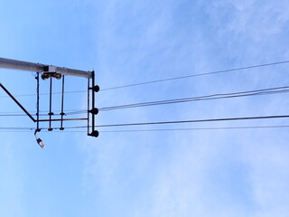 Light pole, power cables standing on the street. The pole with electrical transformer wires.