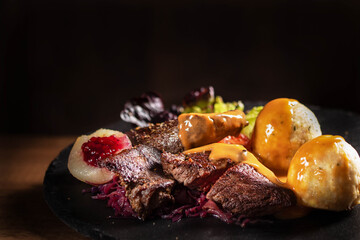 Deutsches Jäger Gericht, Hirschbraten mit Kartoffelknödeln, Salat, Birne und Preiselbeere. Gericht für die echte Männer! Für die Zeitschriften und restaurant