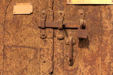 Closeup metal door with lock in grungy style and good texture.