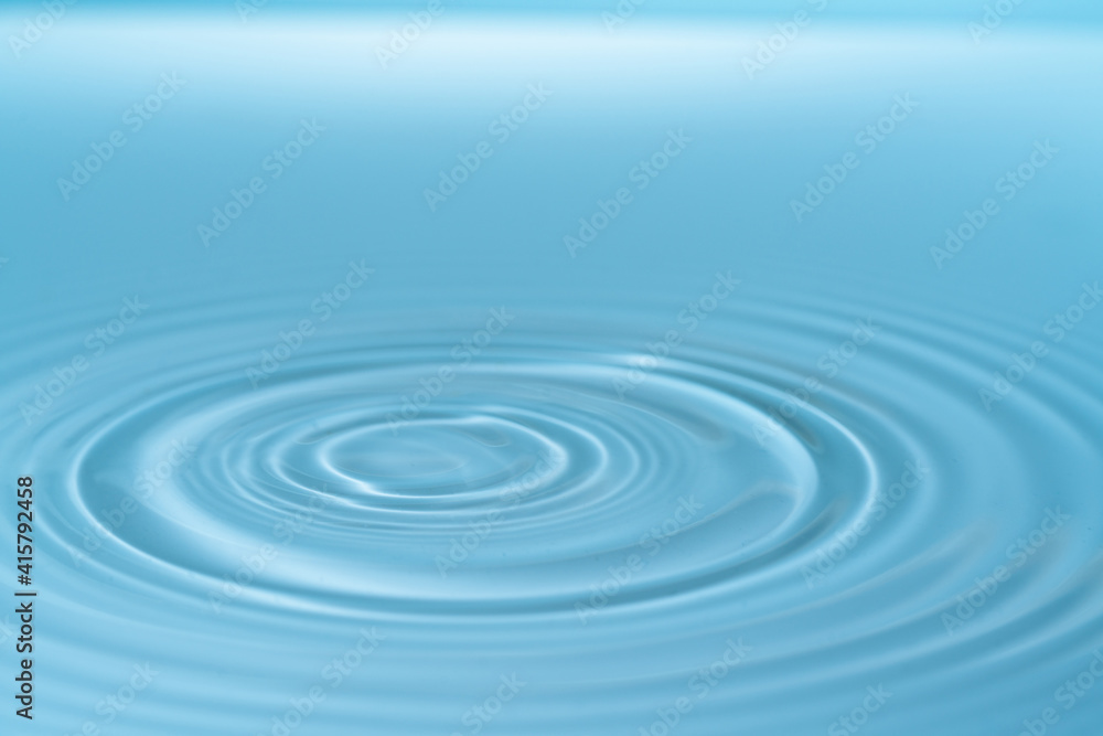 Wall mural drop of water drop to the surface. waves on the surface of the water from a collision