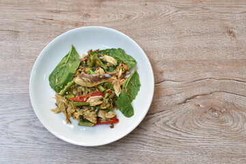 spicy stir fried mackerel fish with slice yard long bean and basil leaf on plate 