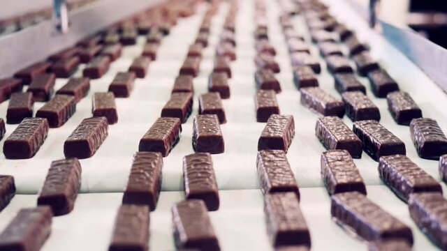 Conveyor belt with chocolate candy bars in a close up