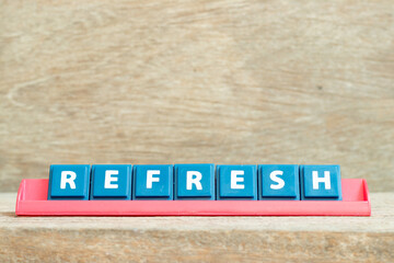 Tile alphabet letter with word refresh in red color rack on wood background