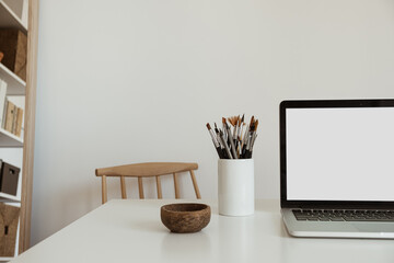 Laptop computer with blank screen on table. Aesthetic minimal office workspace interior design template with mockup copy space.