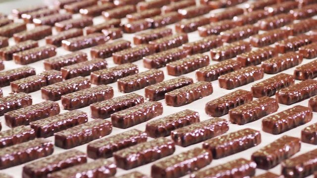 Plenty of chocolate candy bars moving along the factory conveyor