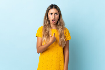 Young hispanic woman over isolated blue background pointing to oneself
