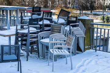 Gestapelte Stühle mit Schnee bedeckt