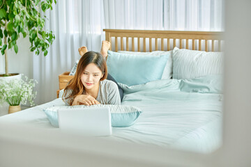 동양인 한국인 아름다운 여성 모델 침대위에서 노트북을 보며 휴식, 쇼핑,...