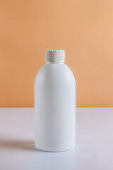 Plastic container for household detergents on on white and beige background