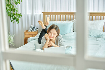 동양인 한국인 아름다운 여성 모델 침대위에서 노트북을 보며 휴식, 쇼핑,...