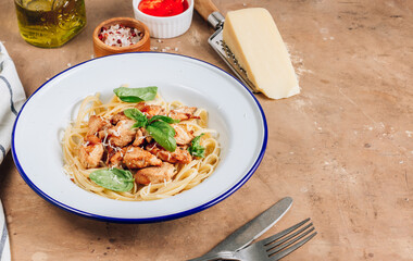 Spaghetti with chicken and basil in an enamel plate