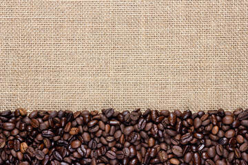 Coffee beans on burlap background. Border design.