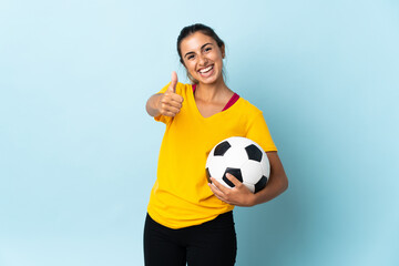 Young hispanic football player woman over isolated on blue background with thumbs up because something good has happened