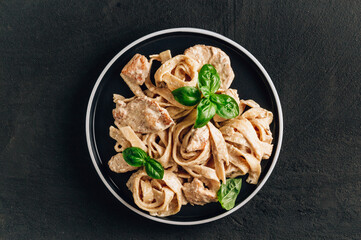 Authentic Italian fettuccine alfredo pasta dish with grilled chicken breast