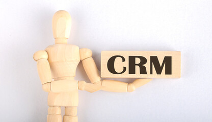 Wooden man shows with a hand to block with text CRM