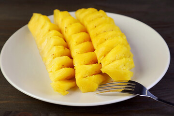Slices of mouthwatering fresh ripe pineapple in white plate