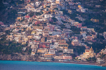 Panoramic view of beautiful yellow, red and white Amalfi houses on hills leading down to coast,...