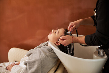 Cute female client relaxing during the hairwash