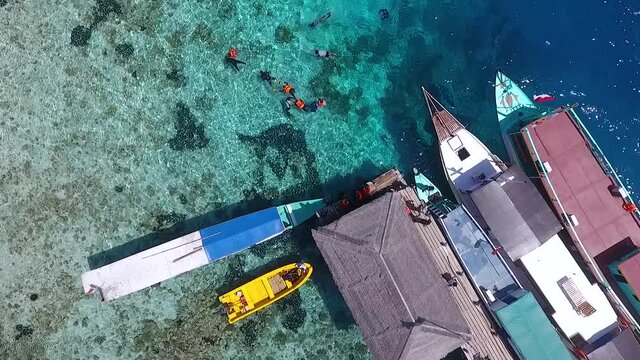 People learn to dive by pier at Kanawa Island, Labuan Bajo, Indonesia. Top view