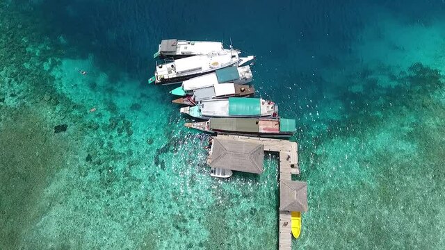 Top view boats at pier on paradise island at tropical destination in Labuan Bajo, Indonesia