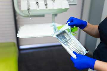 Dentist doctor opening sealed sterile dental instruments
