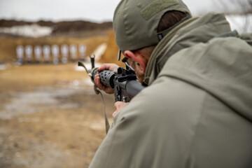 Shooter at the shooting range aiming with mechanical sighting, focus on the rear sight, close-up,...
