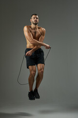 Fototapeta premium Focused athlete getting in shape isolated on grey background in the studio
