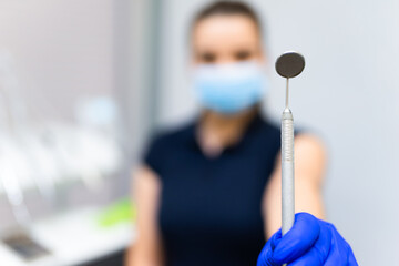 Dentist shows mirror for examine the oral cavity into the camera