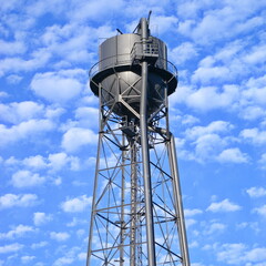 Wassteturm einer stillgelegten Industrieanlage vor blauem Wolkenhimmel bei Sonnenschein im Ruhrpott