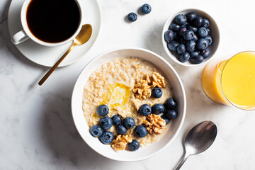 Breakfast concept. Oatmeal with berries and nuts, cup of coffee and glass of orange juice on white background.