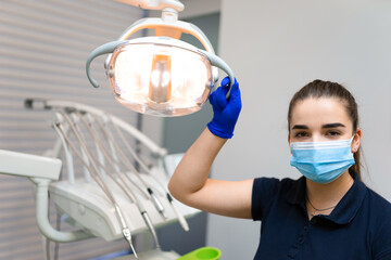 Fototapeta na wymiar Dentist doctor holding a dental lamp with his hand