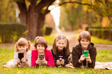 Smartphone addiction group of little children watching film movie cartoon together on digital...