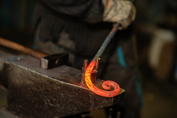 The blacksmith twists the spiral with the help of an anvil, heating the iron blank to red. Work in the forge