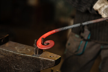 The blacksmith twists the spiral with the help of an anvil, heating the iron blank to red. Work in the forge