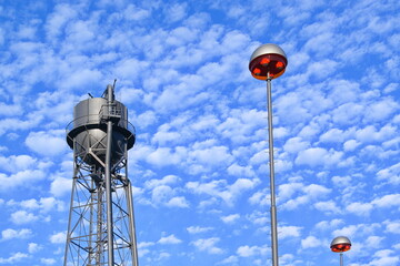 Wasserturm einer stillgelegten Industrieanlage vor blauem Wolkenhimmel bei Sonnenschein im Ruhrpott