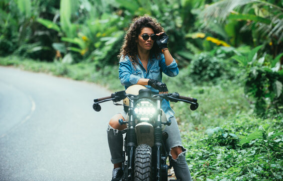 Beautiful girl having fun driving her custom cafe racer motorcycle © oneinchpunch