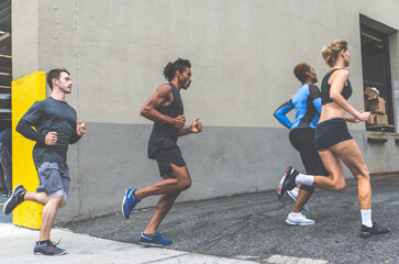 Fototapeta na wymiar Group of urban runners running on the street in New york city, conceptual series about sport and fitness