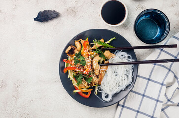 Chicken meat with vegetables wok and Chinese rice noodles, sauces and sesame