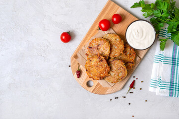 Potato pancakes with sour cream on a light background. Vegetarian dish. Top view. Copy space