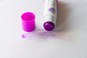 Solid glue in a tube for a child in the form of a purple pencil, which becomes invisible when dried