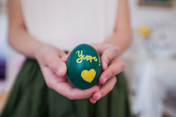 Child hands holding Easter egg at home,closeup view, Holiday day