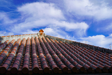 雲影が落ちる赤瓦の屋根　沖縄古民家