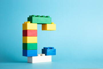 Color plastic building blocks on blue background