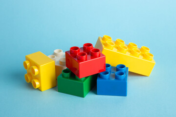 Color plastic building blocks on blue background