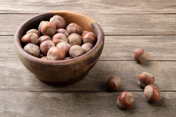 A group of hazelnuts in a bowl over wooden table