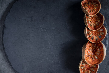 Dry bael on black stone table, free space for text