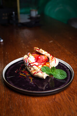 strudel with cream and mint on a black plate
