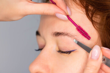 Young Caucasian Woman on the brow beauty procedures. Professional care for face. Brows coloring,...